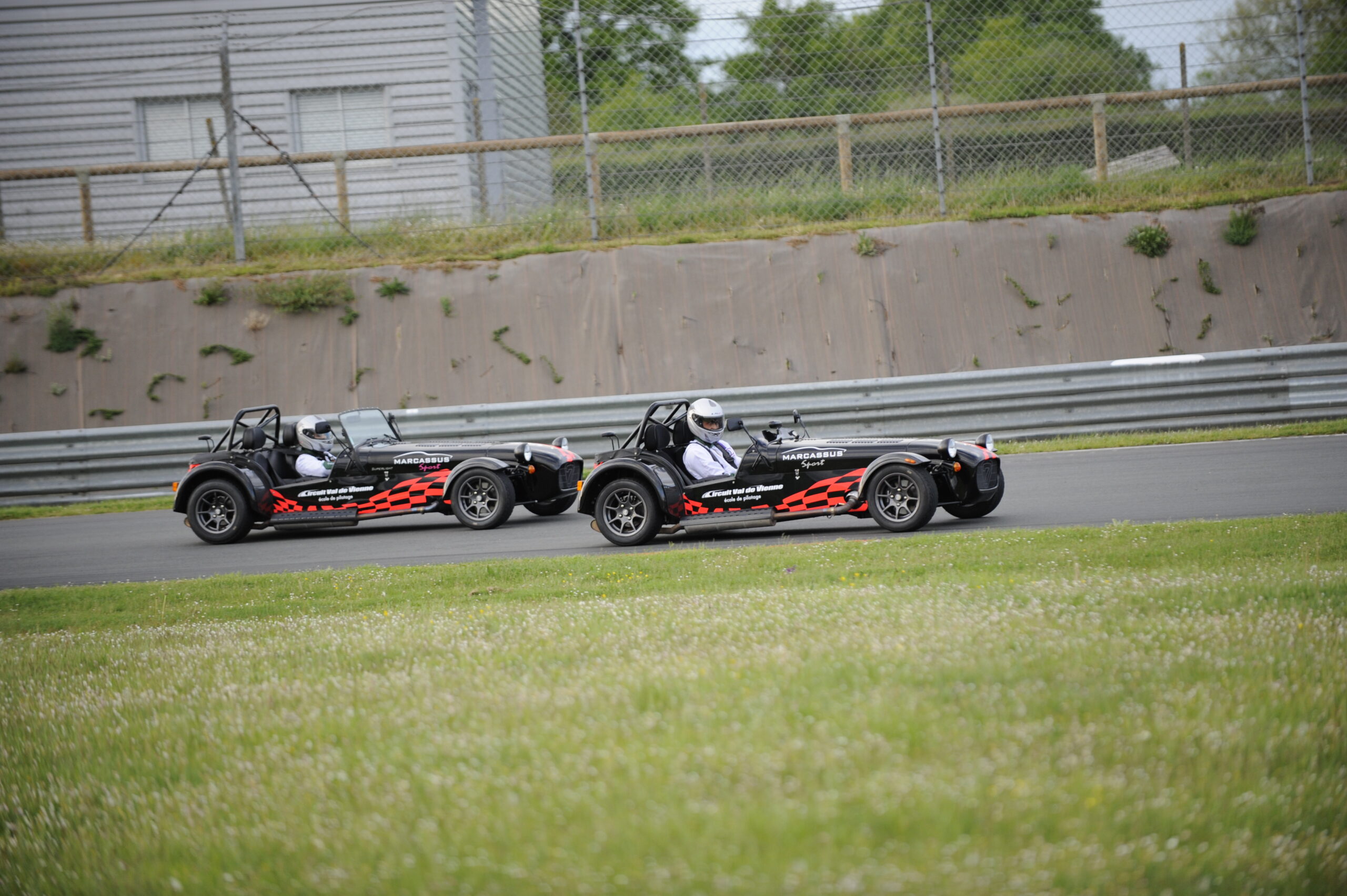 Deux voiture Caterham Superlight noires et blanches sur le circuit